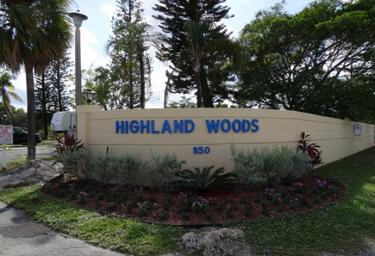 Park entrance sign reading 'Highland Woods' with landscaping — confirms property identity and shows the resort entry area (from the property page).