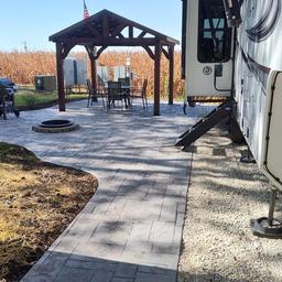 Deluxe patio/site with pergola, firepit and RV slide-out visible — shows an example of premium RV/patio sites referenced on the property page.