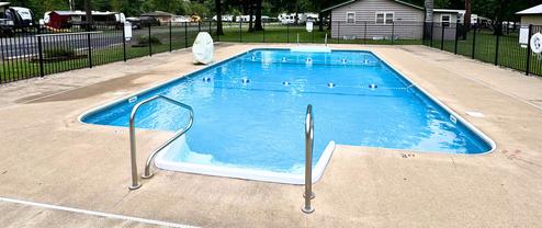 Outdoor swimming pool with fenced area and campground infrastructure visible in background — shows recreational facilities available on the property. Source: pool image on the site.