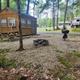 Exterior view of a campsite cabin with picnic table, firepit and an RV in the background — clearly shows on-site cabin accommodations; image is hosted on the property ‘Our Resort’ page (cabin1.jpg).