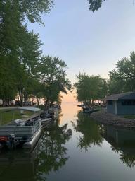 Narrow waterfront channel with parked boats, docks and shore buildings framed by trees — shows the resort’s marina/boat mooring area and appears on the property’s photo gallery pages.