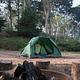 One green tent with trees in the background