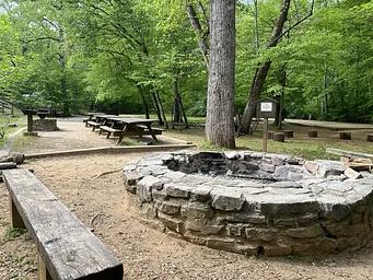 Stone fire ring surrounded by wooden benches