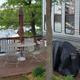 Deck area next to an RV with a view down to the dock — demonstrates RV site patio setup and proximity to the lake and private dock (from the homepage gallery).
