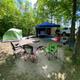 Tent campsite with chairs and vehicle visible in a wooded site — good example of a tent/campsite offering from the property photo gallery.