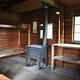 Sergief Island Cabin interior showing wood bunkbeds, shelves and stove