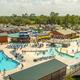 Wide aerial view showing the resort pool complex, activity areas and surrounding campground — good overview of property layout and amenities (matches homepage/gallery content).