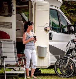 woman having coffee in front of RV