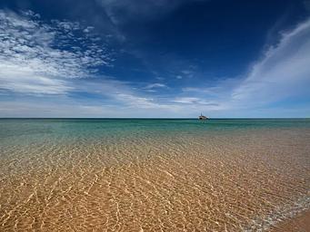 View of the beach and Morazan Shipwreck in the distance under a blue sky from South Manitou Island 