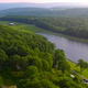 High-resolution aerial view showing the lake, shoreline campsites and surrounding wooded campground — confirms overall layout and setting (source: campground homepage aerial image).