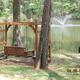 Benched swing by the lake with fountain visible — shows recreational/relaxation spot on the campground (Photo Gallery).