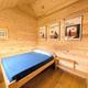 Interior photograph of a small wooden cabin/tiny home (bed and wood paneling) that matches the site’s listed cabin/tiny home accommodations.