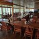 Large indoor dining room with multiple tables and windows overlooking the grounds — represents the resort’s restaurant facility (Restaurant page).