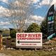 Entrance sign reading 'DEEP RIVER CAMPGROUND' at a landscaped entry — useful property-identifying photo from the campsite website.  (On campground homepage.)