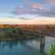 Scenic view of the American River and pedestrian bridge; the RV Park page references nearby American River Parkway and this image illustrates the local riverside scenery accessible from the park.
