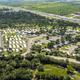 Aerial shot from a different angle that includes the resort, surrounding vegetation and nearby highway — good for location context and layout variety.