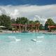 Wide pool view with lounge seating, pergola and landscaping — highlights the on-site swimming facilities and guest amenities (used on the homepage/stay pages).