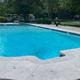 Swimming pool with surrounding landscaping and RVs visible beyond the fence — shows on-site pool amenity; from the park photos gallery page.