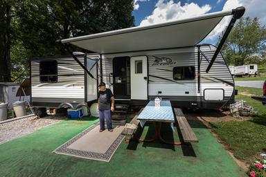 Close view of an RV site with awning, picnic table and mat — represents typical campsite setup and site amenities (gallery image on the campground website).