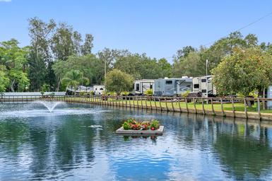 Pond with fountain and RVs along the water — highlights key scenic feature and adjacent RV sites. Matches gallery context (Pond View).