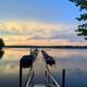 Framed pier view at sunrise/sunset with boats moored — attractive, high-quality image emphasizing the marina/dock and lake ambience (Lake/Marina page).