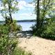 Sandy path through vegetation leading directly to the lake — helpful campsite/beach access view showing how guests reach the water (image appears on the property website).