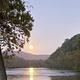 River sunset photograph showing the Shenandoah/river frontage and valley scenery — illustrates the campground's riverside setting shown on the page.