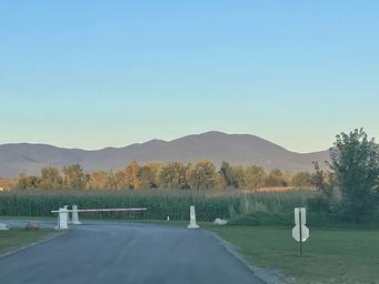 Gated entrance to Riverside Camping & RV Resort with mountains at dusk
