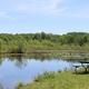 Small lakeside view with picnic table at the water’s edge — supports site reference to natural scenery/ponds on the campground.