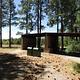 Covered shelters sit surrounded by tall pines