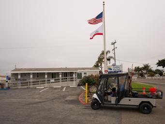 Holiday RV Park's front office and street sign, including one of the maintenance team's utility carts.