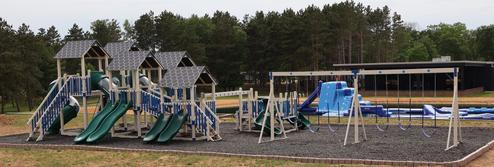 Wide panoramic image of the playground and adjacent aqua/park features — useful overview of family amenities on the property (page context: new playground).