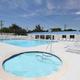 Ground-level pool and spa photo showing amenities, pool deck and clubhouse building — complements aerial pool image (site gallery ‘pool-and-spa pic-2025’).