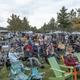 Crowd on the lawn with rows of RVs and campsites visible in the background — shows campsite/RV layout and guest experience on the grounds.