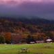 Panoramic meadow with RVs, picnic table and campground buildings with forested hills beyond — another clear overall property view (used on the site's homepage imagery).