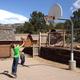 Small basketball court with cabins visible behind it — depicts on-site recreation facilities and proximity to cabin units, supporting the campground amenities shown on the site.