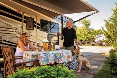 Shows an RV on a concrete pad with outdoor table and landscaping (extended‑stay / RV pad style). Image is from the campground’s 'extended stays' content, indicating it’s an on‑site facility.