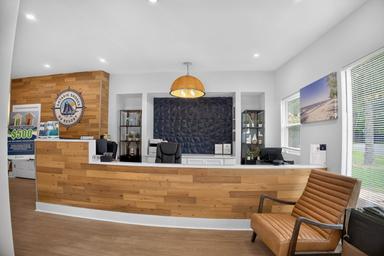 Interior reception desk / office lobby image showing the staffed welcome area and branding — highlights on-site facilities and check-in space (from the site photo gallery).