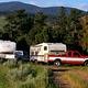 Photo of a trucks and trailers in a campsite area.