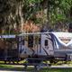 Clear on-site RV pitch showing a travel trailer, picnic table and shaded campsite — good overall view of site layout and amenities; sourced from the property homepage background images.