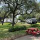 There is a red picnic table in the middle of a park.