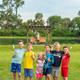 Children posed by a pond with docks and green space in background — shows recreational lakeside area and family-friendly outdoor space on site.