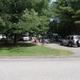 Clear photograph of RV sites and roadways with shaded trees and vehicles — depicts typical RV pitch layout on the property (from the site’s gallery).