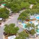Aerial panorama showing the campground layout and main waterpark complex (pools, slides, surrounding RV pads and trees). Matches site homepage hero/social image context.