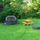 Open grassy tent campsite with picnic table and fire pit — clear depiction of primitive tent camping spots available on the grounds (tent camping image on site).