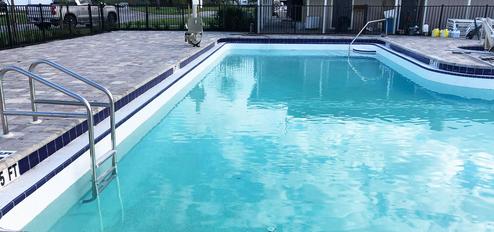Photograph of the resort swimming pool and adjacent deck area (pool ladder, fencing, pool furniture visible). Sourced from the homepage (pool image), indicating an on‑property amenity.
