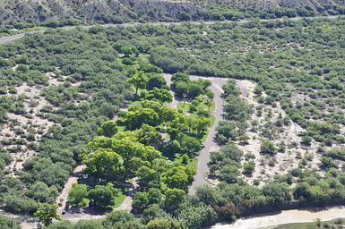 Aerial view of Cottonwood Campground, bright green trees amidst the low desert, riparian area