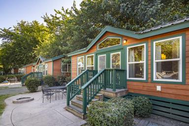 Exterior of multiple park cabins with patio seating and landscaping — demonstrates cabin lodging options available at the campground (image hosted on towerparkresort.com).