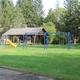 Open grassy play area with playground equipment and pavilion — clearly depicts on-site recreational facilities (slide06b/facilities imagery).