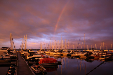 Wide view of the marina with many moored boats and a dock (rainbow/sky) — visually documents the waterfront/marina area referenced on the site.
